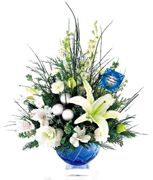 Miami Christmas: Oriental lily, larkspur and lisianthus, all in shades of winter white, make this holiday centerpiece an elegant yet festive statement. Accented with seasonal greens, eucalyptus stems and silver glass balls, its beautifully presented in a blue cut-glass bowl with a distinctive clear, block base. This blue bowl sizes 6 1/2" dia. x 4 1/2"H ORDER NOW 