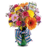 Say thanks a bunch, with this big, beautiful bouquet of bright colored flowers in glass vase with a ribbon. Arrangement includes orange gerbera daisies, yellow cushion pompons, lavender daisy pompons and more. 